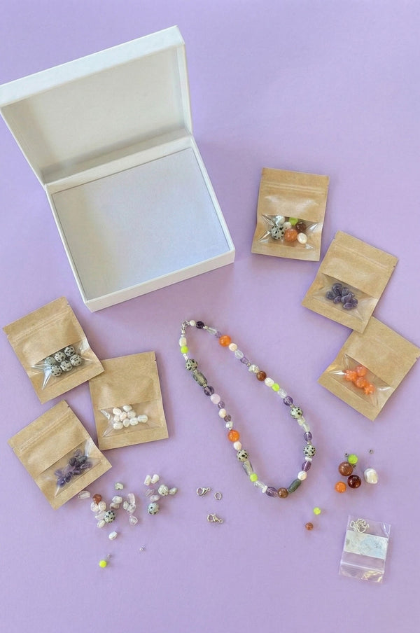 Jewelry-making materials and tools on a purple background