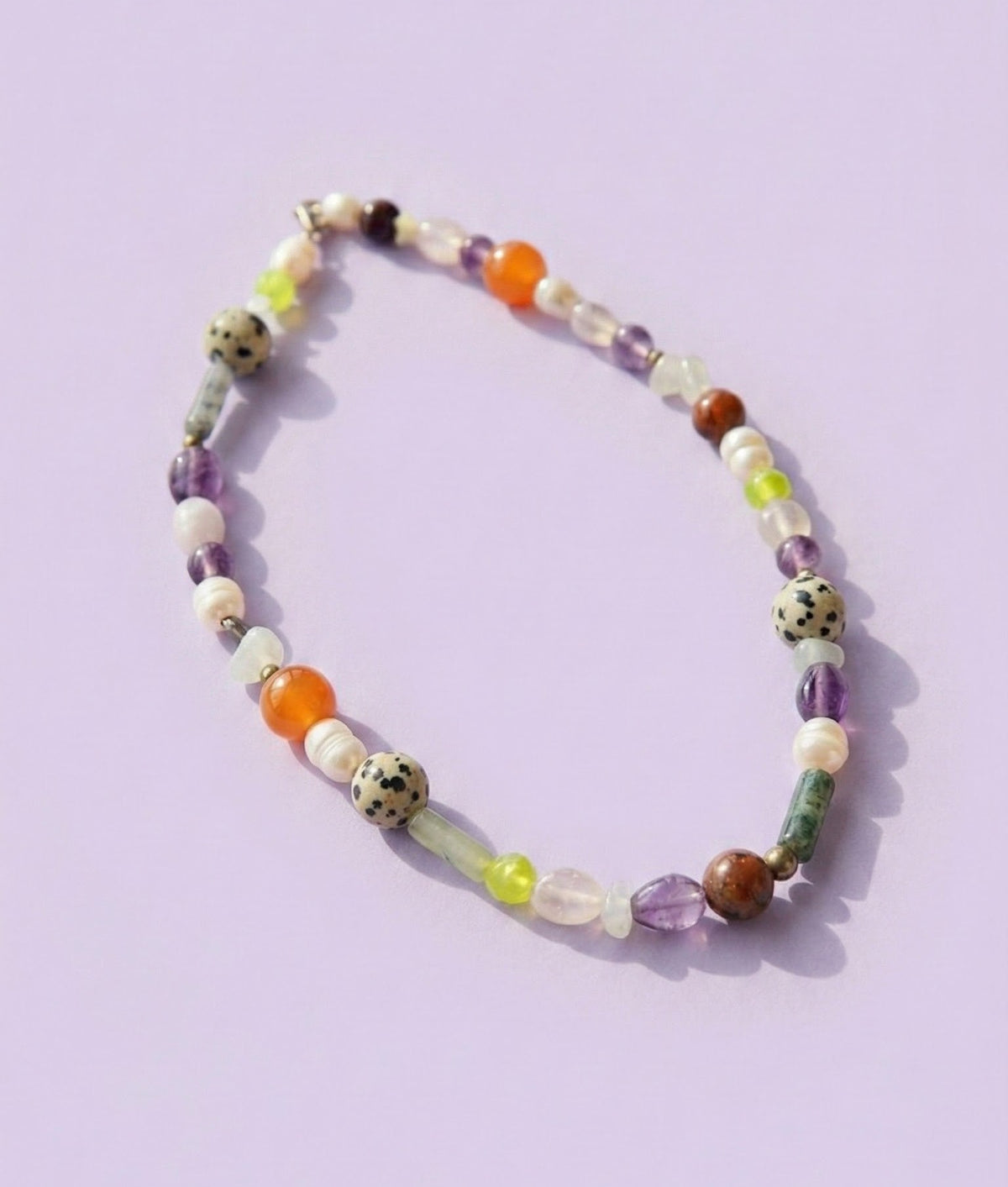 Necklace with multicolored beads on a light purple background